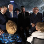 
              President Joe Biden puts his arm around Israeli President Isaac Herzog as he talks with American Holocaust survivors Dr. Gita Cycowicz and Rena Quint in the Hall of Remembrance at Yad Vashem, Wednesday, July 13, 2022, in Jerusalem. (AP Photo/Evan Vucci)
            