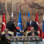 
              IDENTIFIES TWO PEOPLE SHAKING HANDS - Turkish President Recep Tayyip Erdogan, right, and U.N. Secretary General, Antonio Guterres, sit as Sergei Shoigu, Russia's Defense Minister, and Hulusi Akar, Turkey's Defense Minister. shake hands during a signing ceremony at Dolmabahce Palace in Istanbul, Turkey, Friday, July 22, 2022. U.N. Secretary General Antonio Guterres and Turkish President Recep Tayyip Erdogan were due on Friday to oversee the signing of a key agreement that would allow Ukraine to resume its shipment of grain from the Black Sea to world markets and for Russia to export grain and fertilizers, ending a standoff that has threatened world food security. (AP Photo/Khalil Hamra)
            