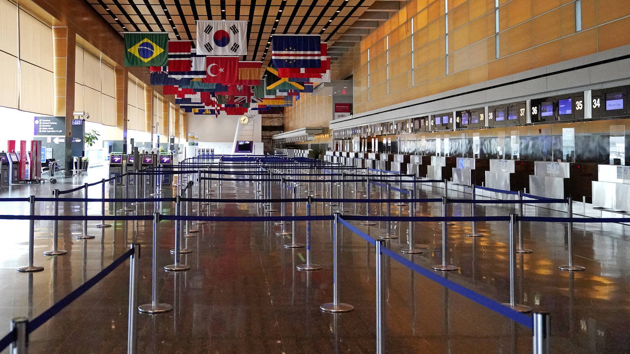 FILE - Flags of countries of the world hang over an empty Terminal E, at Logan Airport in Boston, S...