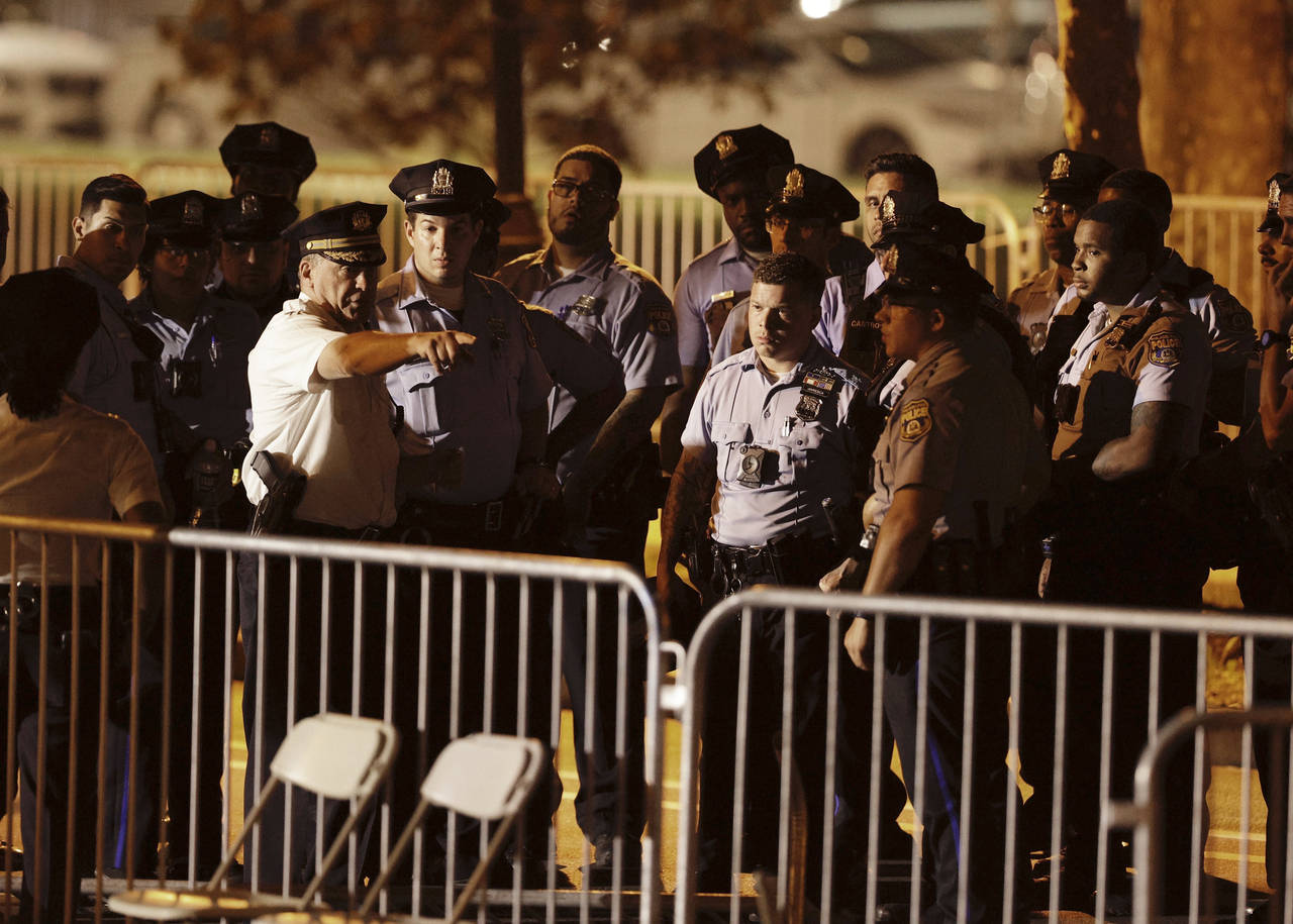 Police begin to search the seating area near the stage after two police officers were shot during t...