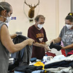 
              Evacuees of the flooding in eastern Kentucky gather clothing at the Knott County Sportsplex in Leburn, Ky., Friday, July 29, 2022. The sportsplex is being used as an emergency shelter, providing food, clothing, and a place to stay for those displaced by the flooding. (AP Photo/Timothy D. Easley)
            