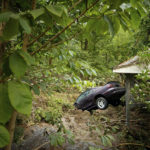 
              A car sinks down into the ground, Thursday, July 14, 2022, in Whitewood, Va., after being swept away in a flash flood. Virginia Gov. Glenn Youngkin declared a state of emergency to aid in the rescue and recovery efforts from Tuesday's floodwaters. (AP Photo/Michael Clubb)
            