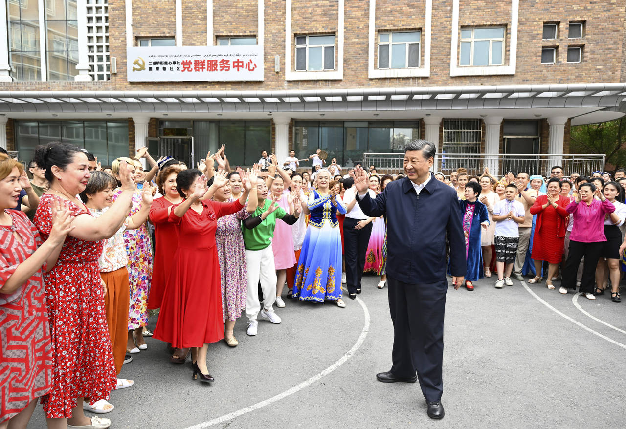 In this photo released by China's Xinhua News Agency, Chinese President Xi Jinping, center, visits ...