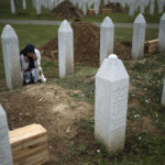 
              A woman prays near a grave of her family member in the Memorial centre in Potocari, Bosnia, Friday, July 8, 2022. After surviving the 1995 Srebrenica massacre in which over 8,000 of their male relatives were killed, women from the small town in eastern Bosnia dedicated the remaining years of their lives to the re-telling of their trauma to the World, honoring the victims and bringing those responsible for  the killings to justice. (AP Photo/Armin Durgut)
            