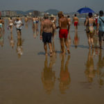 
              People cool off while walking along the beach in Laredo, northern Spain, Monday, July 18, 2022. (AP Photo/Alvaro Barrientos)
            