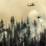 
              Seen from unincorporated Mariposa County, Calif., a helicopter drops water on the Washburn Fire burning in Yosemite National Park on Saturday, July 9, 2022. (AP Photo/Noah Berger)
            