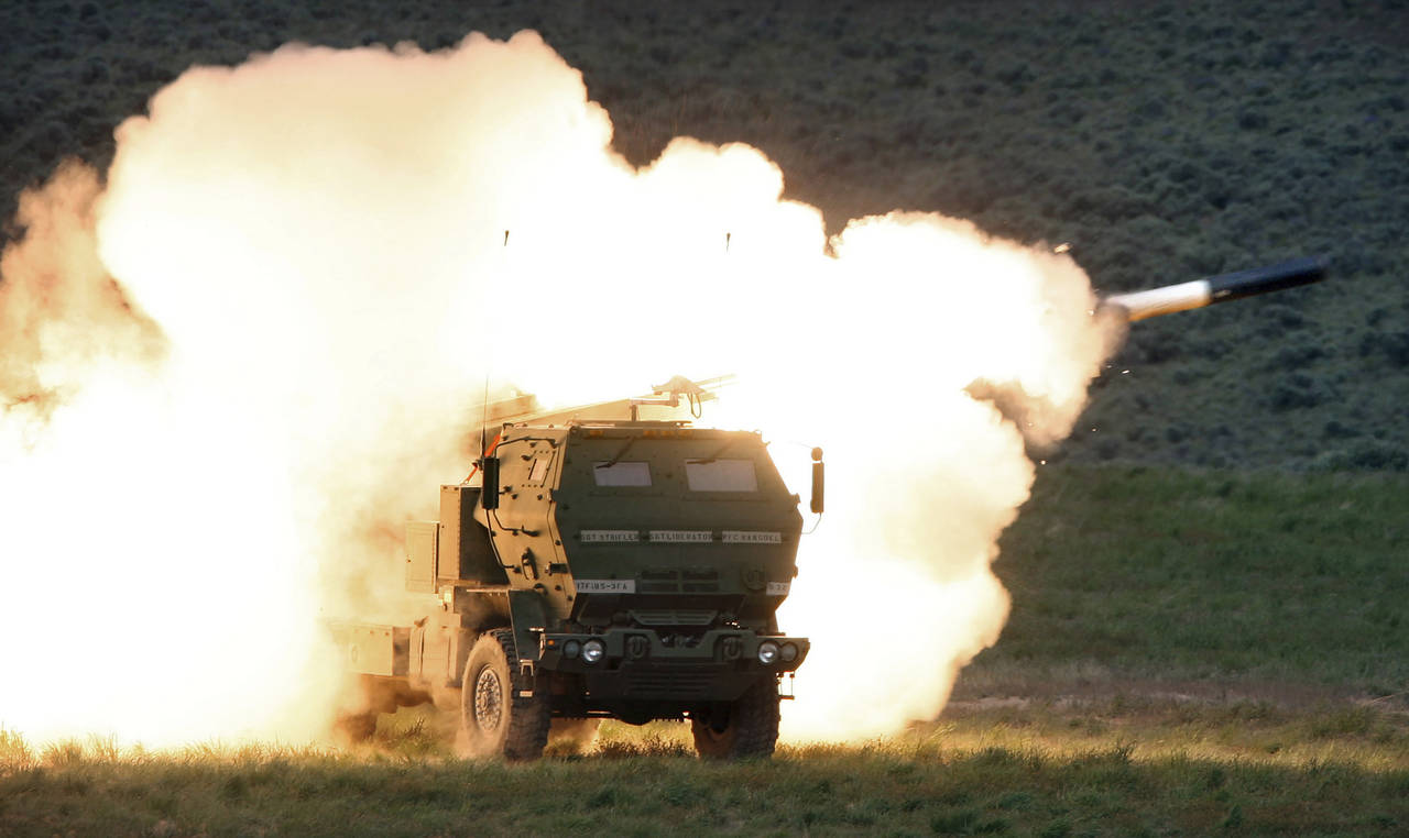 FILE - A launch truck fires the High Mobility Artillery Rocket System (HIMARS) produced by Lockheed...
