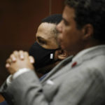 
              Eric Holder Jr., rear, who is accused of killing rapper Nipsey Hussle, sits in a courtroom with his attorney, Aaron Jansen, after the verdicts were read in Los Angeles, Wednesday, July 6, 2022. (AP Photo/Jae C. Hong, Pool)
            