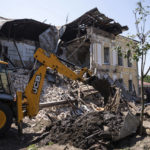 
              An excavator clear the rubble of military registration office destroyed by Russian attack in Kharkiv, Ukraine, Wednesday, July 6, 2022. (AP Photo/Evgeniy Maloletka)
            