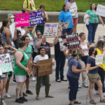 
              Abortion-rights protestors march between the Indiana Statehouse and the Indiana State Library where Vice President Kamala Harris was meeting with Indiana legislators to discuss reproductive right in Indianapolis, Monday, July 25, 2022. The Indiana legislature is starting a special legislative session to address new abortion laws and refunds to residents from the states budget surplus. (AP Photo/Michael Conroy)
            