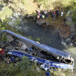 
              A view of the wreckage of a bus that plunged into Nithi bridge on Sunday, in Tharaka Nithi county Meru, Kenya, Monday, July 25, 2022. Police in Kenya say at least 21 people have died after a bus fell off a bridge and plunged into a river along the highway from the capital, Nairobi, to the central town of Meru. One senior policeman said the bus, traveling from Meru, “must have developed brake failure because it was at a very high speed" when the crash occurred. (AP Photo/Dennis Dibondo)
            