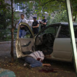 
              FILE - A dead body of a man killed by the Russian shelling lies by his car in city center in Slovyansk, Donetsk region, Ukraine, Monday, June 27, 2022. (AP Photo/Efrem Lukatsky, File)
            