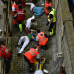 
              Medics attend to injured runners after the "encierro" at the San Fermin festival in Pamplona, northern Spain, Monday, July 11, 2022. The festival highlight is undoubtedly the morning "encierros," or runs, that see hundreds of people of all ages _ mostly men _ testing their agility and bravery to run like mad with six fighting bulls and their guiding steer along an 875-meter (956-yard) route to Pamplona's bullring, where later in the day the bulls are killed by professional bullfighters. (AP Photo/Alvaro Barrientos)
            