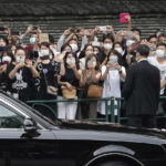 
              Bystanders on the street send off the hearse carrying the body of former Japanese Prime Minister Shinzo Abe as it leaves Zojoji temple after his funeral in Tokyo on Tuesday, July 12, 2022. Abe was assassinated Friday while campaigning in Nara, western Japan. (AP Photo/Hiro Komae)
            