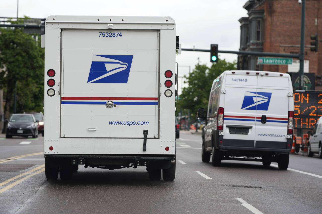 FILE - A USPS logo adorns the back doors of United States Postal Service delivery vehicles as they ...