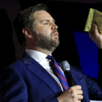 
              FILE - Republican Senate candidate JD Vance holds a piece of paper with the name of former President Donald Trump written on it, as he speaks May 3, 2022, in Cincinnati. (AP Photo/Aaron Doster, File)
            