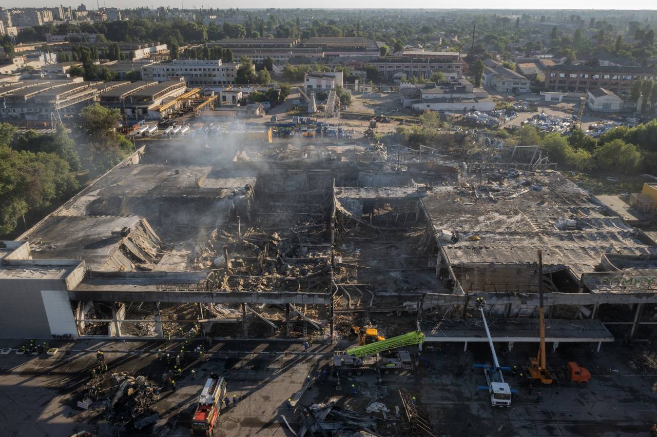 FILE - Ukrainian State Emergency Service firefighters work to take away debris at a shopping center...