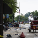 
              Members of the FBI's Evidence Response Team Unit investigate in downtown Highland Park, Ill., the day after a deadly mass shooting on Tuesday, July 5, 2022.   Police say the gunman who attacked an Independence Day parade in suburban Chicago fired more than 70 rounds with an AR-15-style gun.   (Ashlee Rezin /Chicago Sun-Times via AP)
            