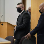 
              Volodymyr Zhukovskyy, of West Springfield, Mass., center, charged with negligent homicide in the deaths of seven motorcycle club members in a 2019 crash, enters a courtroom at Coos County Superior Court in Lancaster, N.H., Tuesday, July 26, 2022, before opening statements in his trial. Zhukovskyy has pleaded not guilty to multiple counts of negligent homicide, manslaughter, reckless conduct and driving under the influence in the June 21, 2019, crash. (AP Photo/Steven Senne, Pool)
            