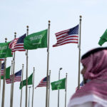 
              A man stands under American and Saudi Arabian flags prior to a visit by U. S. President Joe Biden, at a square in Jeddah, Saudi Arabia, Thursday, July 14, 2022. (AP Photo/Amr Nabil)
            