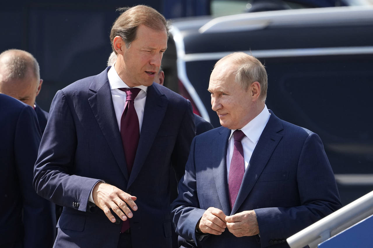 FILE - Russian President Vladimir Putin, right, and Russian Industry and Trade Minister Denis Mantu...