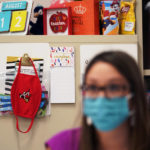 
              FILE - Wearing a mask to protect against the spread of COVID-19, kindergarten teacher Amber Ximenz prepares her classroom at Southside Independent School District in San Antonio, on Aug. 13, 2020. Texas Gov. Greg Abbott’s executive order that forbids school districts from imposing mask mandates on schools to prevent the spread of COVID-19 was upheld Monday, July 25, 2022, by a divided federal appeals court panel in New Orleans. (AP Photo/Eric Gay, File)
            