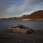 
              FILE - A formerly sunken boat sits high and dry along the shoreline of Lake Mead at the Lake Mead National Recreation Area, on May 10, 2022, near Boulder City, Nev. Wildfires, floods and soaring temperatures have made climate change real to many Americans. Yet a sizeable number continue to dismiss the scientific consensus that human activity is to blame. That's in part because of a decades-long campaign by fossil fuel companies to muddy the facts and promote fringe explanations. (AP Photo/John Locher, File)
            