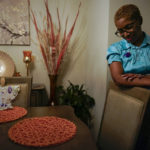 
              CORRECTS SPELLING FROM ONLEY TO OLNEY -Nadine Thomas pauses as she talks about her daughter Nikiesha Thomas at her dining room table in Olney, Md., Thursday, Aug. 25, 2022, and the angel with purple flowers were given to her after Nikiesha was shot and killed by her ex-boy boyfriend just days after filing for a protective order last October. Victims of abuse and their families saw a quiet breakthrough this summer when the passage of a bipartisan gun safety bill in Congress included a proposal that would make it more difficult for intimate partners of convicted domestic abusers to obtain firearms. (AP Photo/Carolyn Kaster)
            