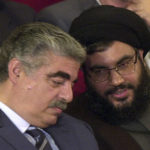 
              FILE - Former Lebanese Prime Minister Rafik Hariri, left, talks with Hezbollah leader Sheik Hassan Nasrallah, right, during an official ceremony to mark the first anniversary of the Israeli withdrawal from south Lebanon, in Beirut, Lebanon, May 25, 2001. Forty years since it was founded, Lebanon's Hezbollah has transformed from a ragtag organization to the largest and most heavily armed militant group in the Middle East. (AP Photo/Mahmoud Tawil, File)
            