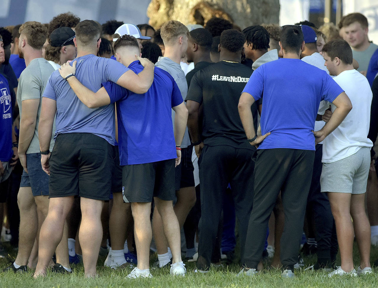 Members of the Indiana State football team console one another after a vigil at Memorial Stadium in...
