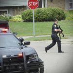 
              Police investigate a shooting Friday, Aug. 5, 2022, in Butler Township, Ohio.  Authorities say four people were shot to death in the Ohio suburb and a man considered armed and dangerous is being sought. (Marshall Gorby /Dayton Daily News via AP)
            