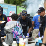 
              Bowling Green Police Chief Michael Delaney, center, hands out burgers alongside a group of officers at the Back to School Block Party in front of Mount Zion Baptist Church in Bowling Green, Ky., Saturday, July 30, 2022. (Grace Ramey/Bowling Green Daily News via AP)
            
