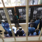 
              Schoolchildren look at photographs of young Black students at Cyrene Mission School at the National Gallery of Zimbabwe, Tuesday July 26, 2022. The Black students portraits are part of a historic exhibit, "The Stars are Bright," now showing in Zimbabwe for the first time since the collection left the country more than 70 years ago. (AP Photo/Tsvangirayi Mukwazhi)
            