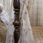 
              A woman prays in the special rest room for the Guru Granth Sahib, the Sikh holy book, where it resides during the evening hours at the Guru Nanak Darbar of Long Island, a Sikh gurudwara, Wednesday, Aug. 24, 2022, in Hicksville, N.Y. An Afghan Sikh family of 13 has found refuge in the diaspora community on Long Island where the Sikh community is helping family members obtain work permits, housing, healthcare and find schools for the children. (AP Photo/John Minchillo)
            