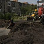 
              Workers drain water from a crater created by an explosion that damaged a residential building after a Russian attack in Slovyansk, Ukraine, Sunday, Aug. 28, 2022. (AP Photo/Leo Correa)
            