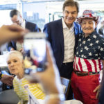 
              Republican nominee for U.S. Senate, Dr. Mehmet Oz, center, drops by The Capitol Diner, Friday, Aug. 12, 2022, in Swatara Township, Pa. (Sean Simmers/The Patriot-News via AP)
            