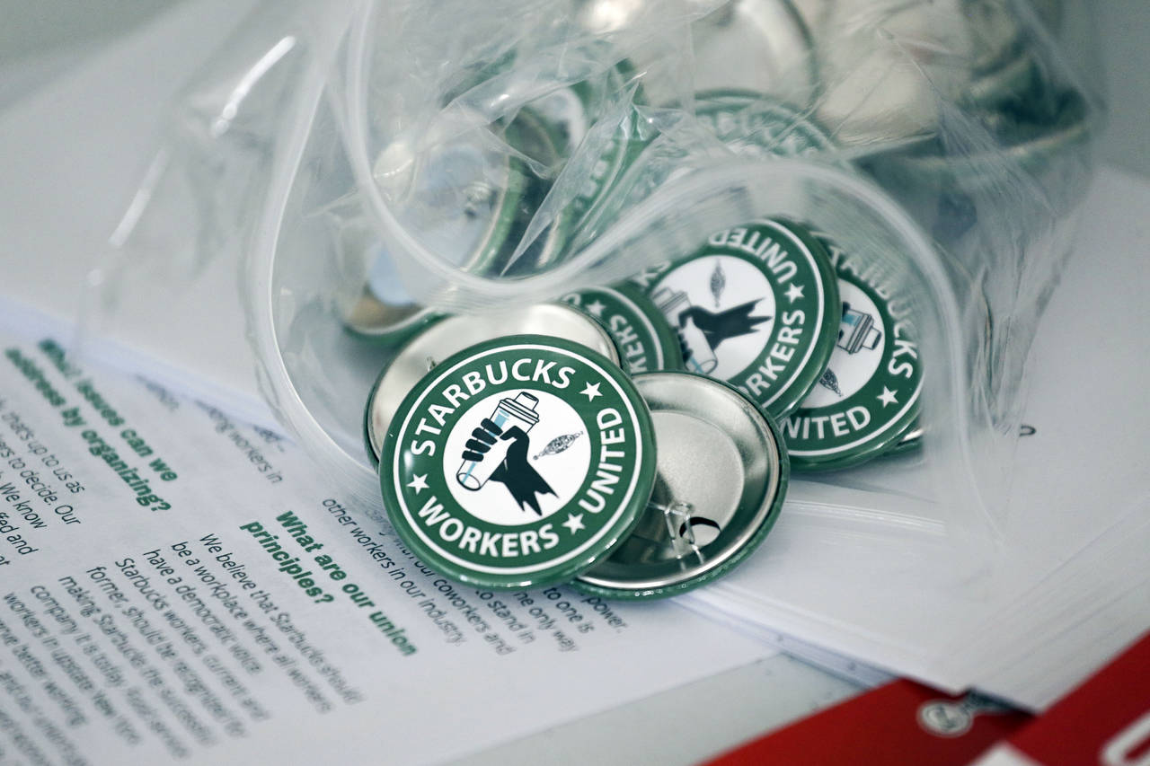 FILE — Pro-union pins sit on a table during a watch party for Starbucks' employees union election...