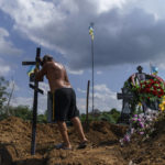 
              A cemetery worker places a cross on the grave of Serhiy Marchenko following his burial in Pokrovsk, Donetsk region, eastern Ukraine, Thursday, Aug. 4, 2022. Marchenko, 26, a Ukrainian soldier who was fighting in an artillery squad in the Donetsk region when he was killed on July 28. (AP Photo/David Goldman)
            