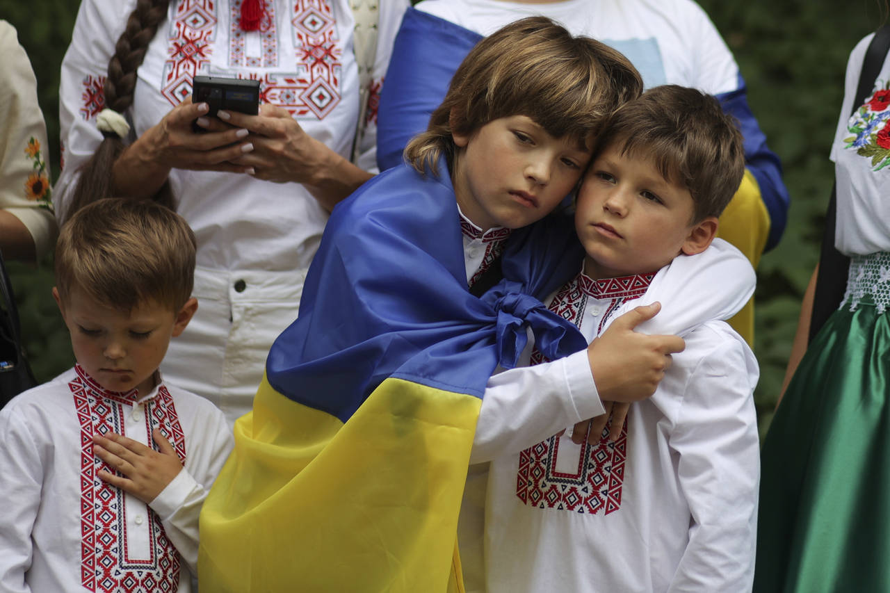 Ukrainians sing a national anthem as part of the celebration of Ukrainian's Independence Day in War...