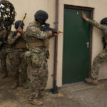 
              Ukrainian volunteer military recruits take part in an urban battle exercise whilst being trained by British Armed Forces at a military base in Southern England, Monday, Aug. 15, 2022. MOD and British Army as the UK Armed Forces continue to deliver international training of Ukrainian Armed Forces recruits in the United Kingdom.(AP Photo/Frank Augstein)
            