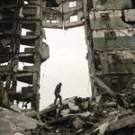 
              FILE - A resident looks for belongings in an apartment building destroyed during fighting between Ukrainian and Russian forces in Borodyanka, Ukraine, April 5, 2022. Six months ago, Russian President Vladimir Putin sent troops into Ukraine in an unprovoked act of aggression, starting the largest military conflict in Europe since World War II. Putin expected a quick victory but it has turned into a grinding war of attrition. Russian offensive are largely stuck as Ukrainian forces increasingly target key facilities far behind the front lines. (AP Photo/Vadim Ghirda, File)
            