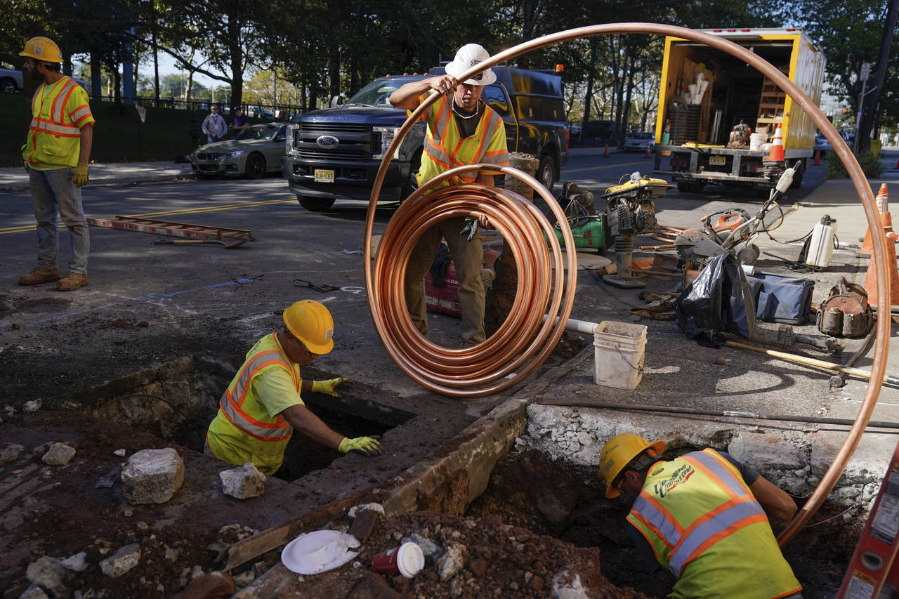 FILE - Workmen prepare to replace older water pipes with a new copper one in Newark, N.J., Thursday...