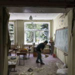 
              A worker cleans up after an early morning rocket attack hit the Kramatorsk College of Technologies and Design in Kramatorsk, Donetsk region, eastern Ukraine, Friday, Aug. 19, 2022. Russia continued to shell towns and villages in Ukraine's embattled eastern Donetsk region, according to regional authorities, where Russian forces are pushing to overtake areas still held by Ukraine. (AP Photo/David Goldman)
            