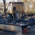 
              In this January 2019 photo provided by Sue Womack, James Holden sifts through the remains of his family's homestead, which burned to the ground in a 2018 wildfire, in Paradise, Calif. After fleeing one of the most destructive fires in California, the Holden family wanted to find a place that had not been so severely affected by climate change and chose Vermont. (Sue Womack via AP)
            