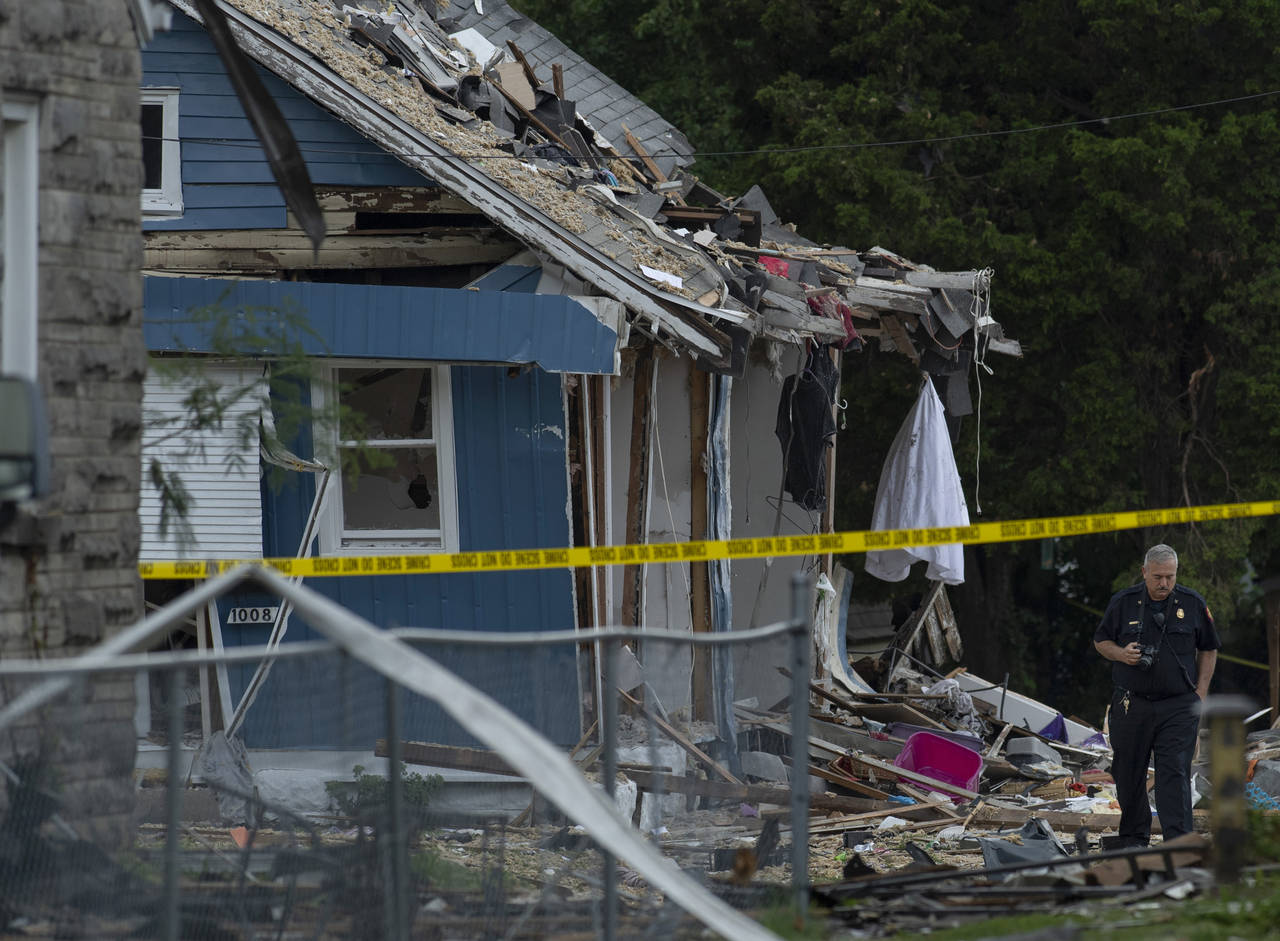 Evansville Fire Department personnel examine the scene after a house explosion at 1010 N. Weinbach ...