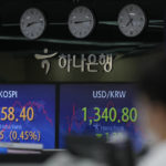 
              A currency trader walks near screens showing the Korea Composite Stock Price Index (KOSPI), left, and the foreign exchange rate between U.S. dollar and South Korean won at a foreign exchange dealing room in Seoul, South Korea, Thursday, Aug. 25, 2022. Asian shares were mostly higher Thursday as Wall Street and global markets wait for a highly anticipated speech from the U.S. Federal Reserve chair about interest rates at the end of the week. (AP Photo/Lee Jin-man)
            
