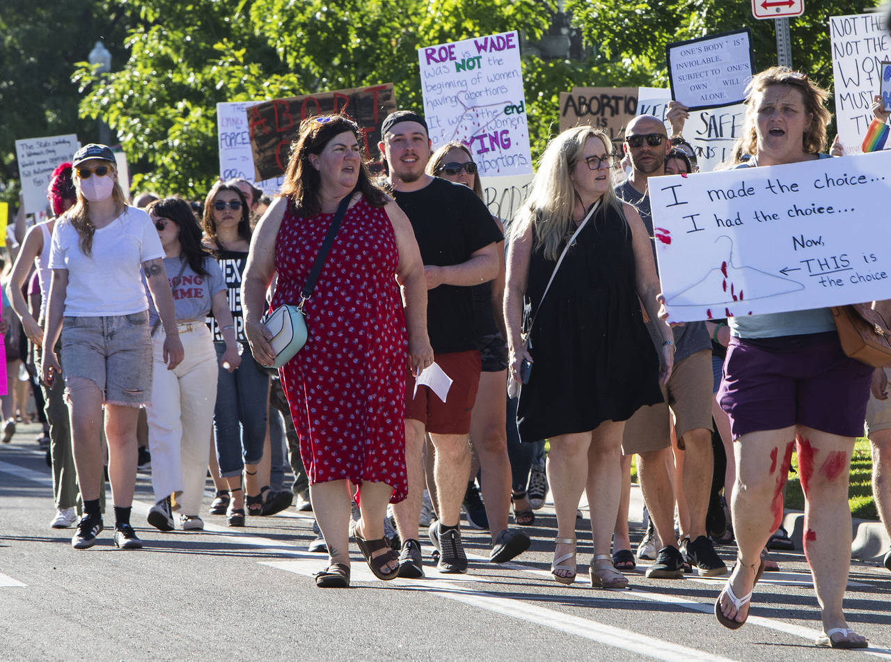 FILE - Protestors march through downtown Boise chanting pro-abortion rights slogans on their way to...