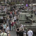 
              Ukrainians visit an avenue, where destroyed Russian military vehicles have been displayed in Kyiv, Ukraine, Saturday, Aug. 20, 2022. Drawing the attention of large numbers of pedestrians and amateur snappers on Saturday in downtown Kyiv a large column of burned out and captured Russian tanks and infantry carriers were displayed on the central Khreshchatyk boulevard. (AP Photo/Andrew Kravchenko)
            