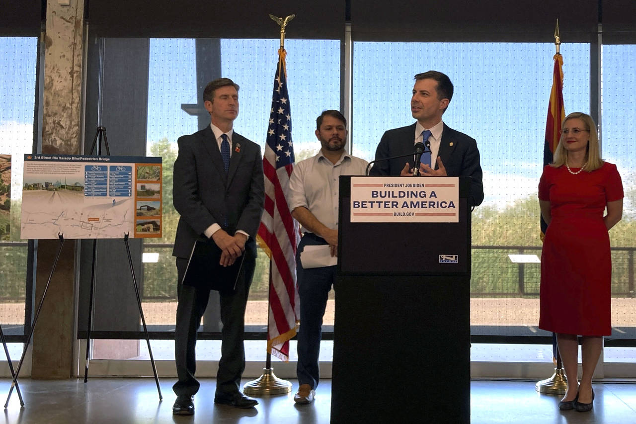 Transportation Secretary Pete Buttigieg, center, flanked by, from left to right, Congressman Greg S...