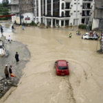 
              People and vehicles navigate through flooded roads after heavy monsoon rains in Mingora, the capital of Swat valley in Pakistan, Saturday, Aug. 27, 2022. Officials say flash floods triggered by heavy monsoon rains across much of Pakistan have killed nearly 1,000 people and displaced thousands more since mid-June. (AP Photo/Naveed Ali)
            